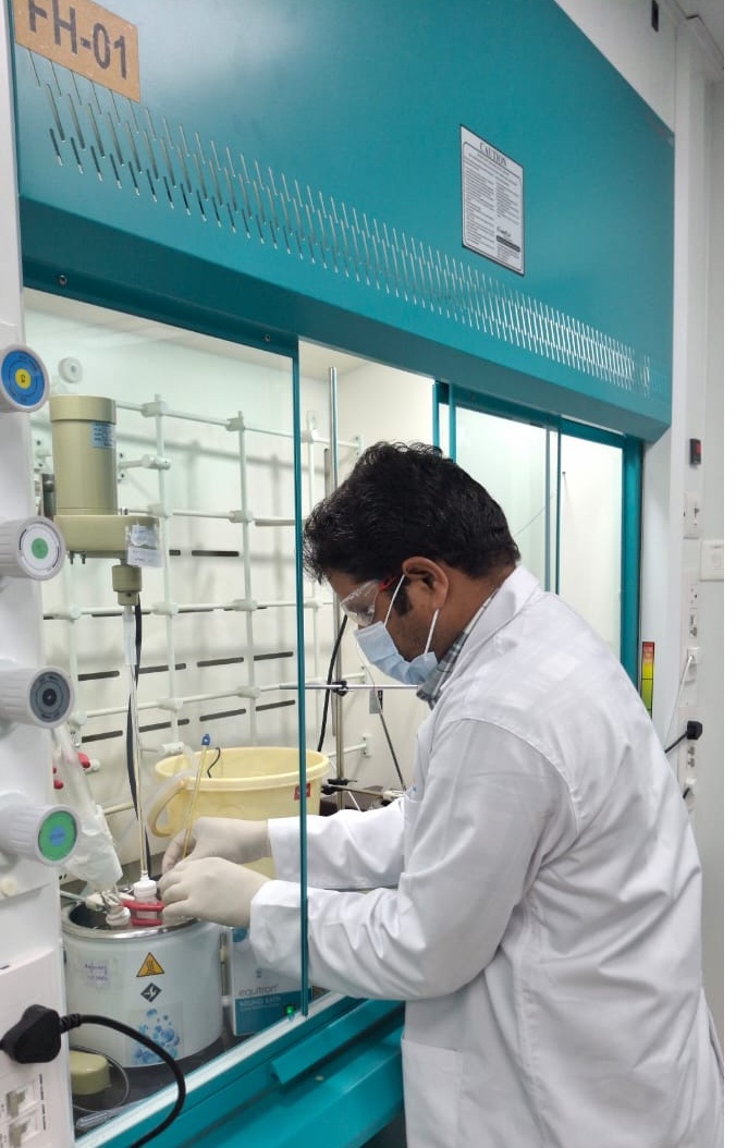 Scientist Operating Controlled Synthesis Reactor in Fume Hood